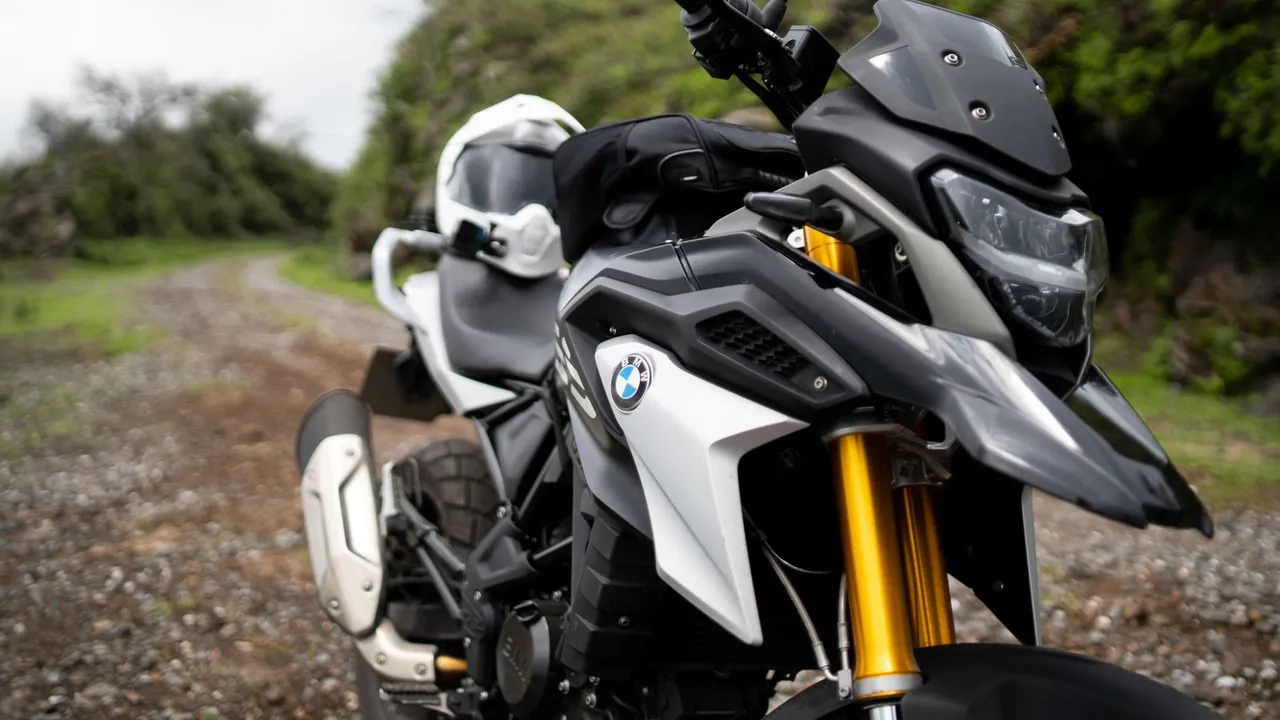 BMW R 1250 GS grise de profil sur une route de montagne, valises latérales montées